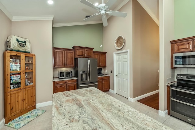 kitchen featuring light tile patterned flooring, stainless steel appliances, light stone countertops, and backsplash