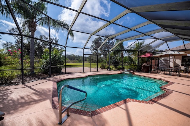 view of swimming pool featuring a patio area and glass enclosure