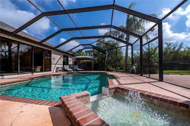 view of swimming pool with an in ground hot tub, a patio, and glass enclosure