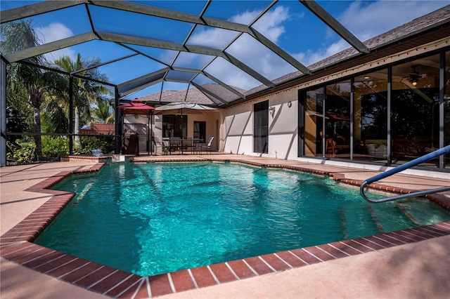 view of swimming pool featuring ceiling fan, a lanai, and a patio