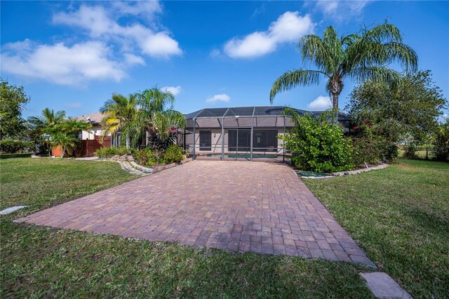 rear view of property featuring a lanai and a lawn