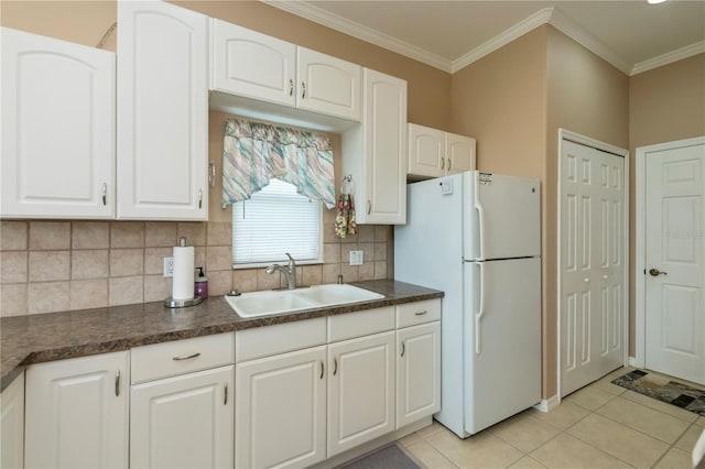 2002 Palm View Rd, Sarasota, FL 34240 - kitchen featuring freestanding refrigerator, dark countertops, backsplash, white cabinets, and light tile patterned floors