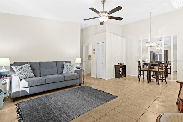 living room featuring ceiling fan with notable chandelier, high vaulted ceiling, and light tile patterned flooring