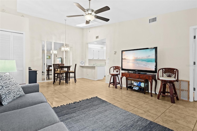 living room with ceiling fan with notable chandelier, light tile patterned floors, and lofted ceiling