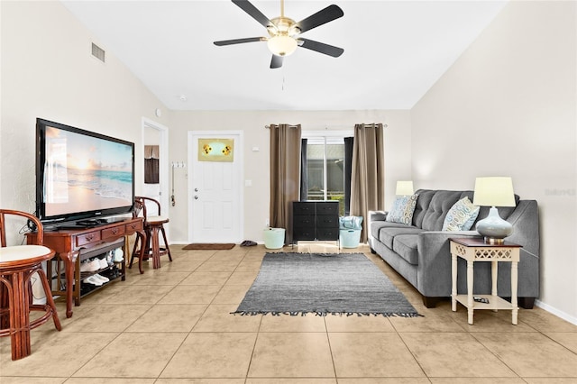 living room featuring vaulted ceiling, light tile patterned floors, and ceiling fan