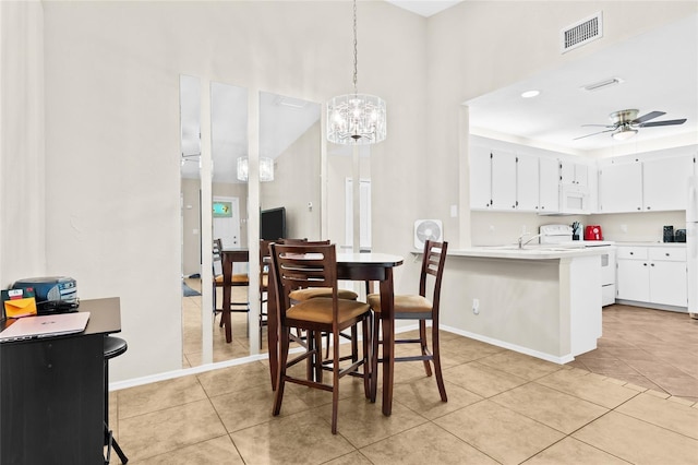 dining area featuring light tile patterned flooring and ceiling fan with notable chandelier