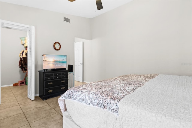 bedroom with a walk in closet, tile patterned floors, a closet, and ceiling fan