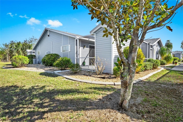 view of front facade with central AC and a front lawn