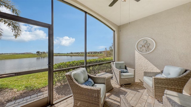 sunroom / solarium with ceiling fan and a water view