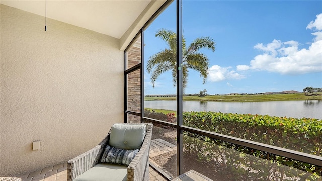 sunroom featuring a water view