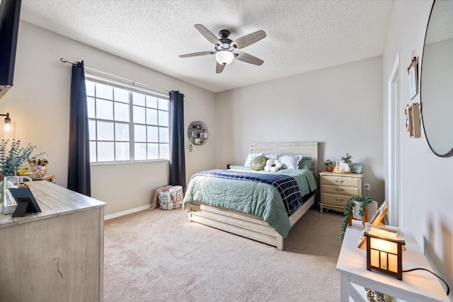 carpeted bedroom featuring ceiling fan and a textured ceiling