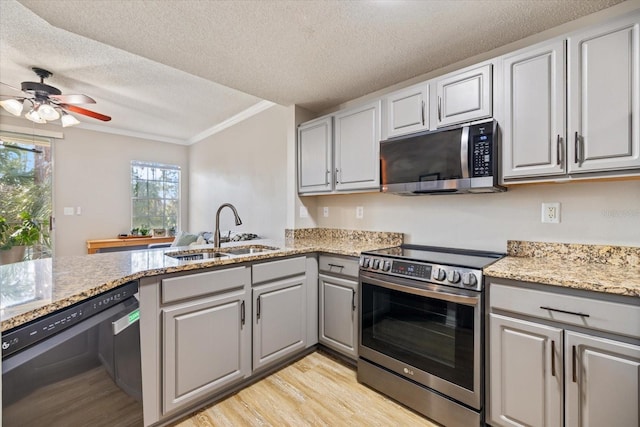 kitchen with sink, gray cabinetry, crown molding, light hardwood / wood-style flooring, and stainless steel appliances