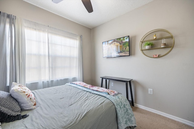 bedroom with ceiling fan, a textured ceiling, and carpet flooring