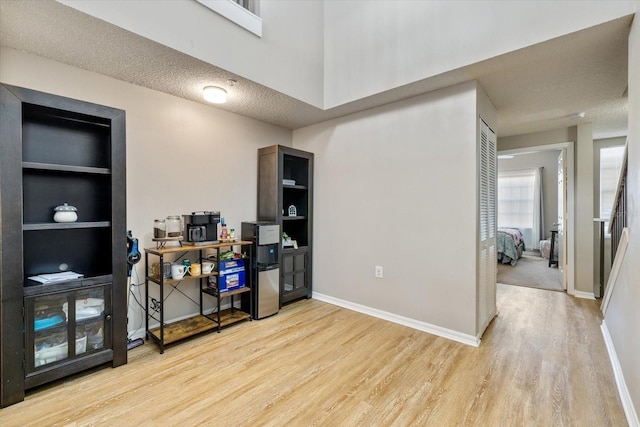 office space with light hardwood / wood-style flooring, built in features, and a textured ceiling