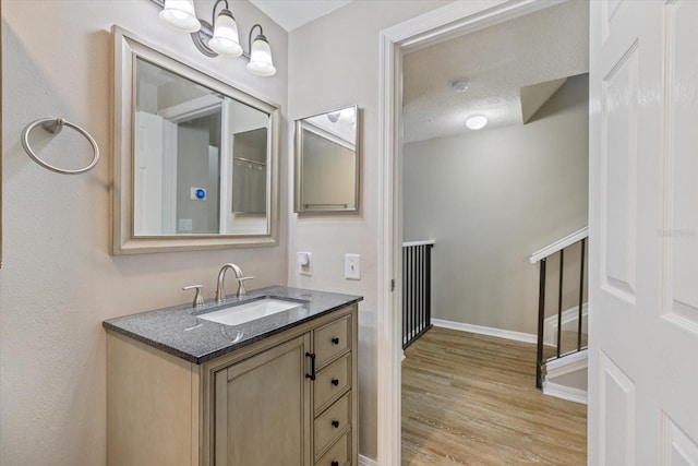 bathroom with vanity, wood-type flooring, and a textured ceiling