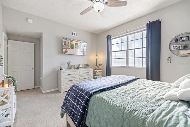 carpeted bedroom with ceiling fan and a textured ceiling