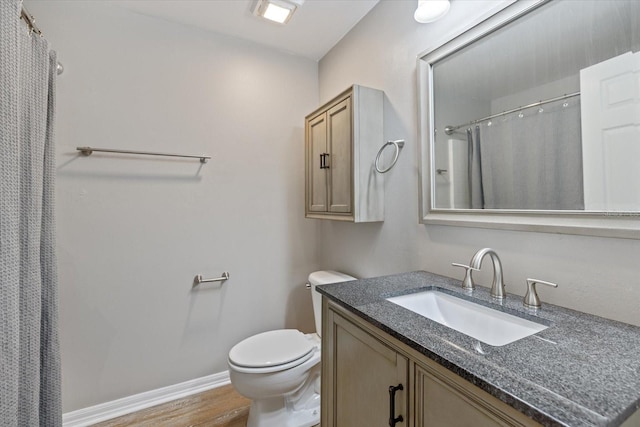 bathroom featuring vanity, hardwood / wood-style floors, and toilet