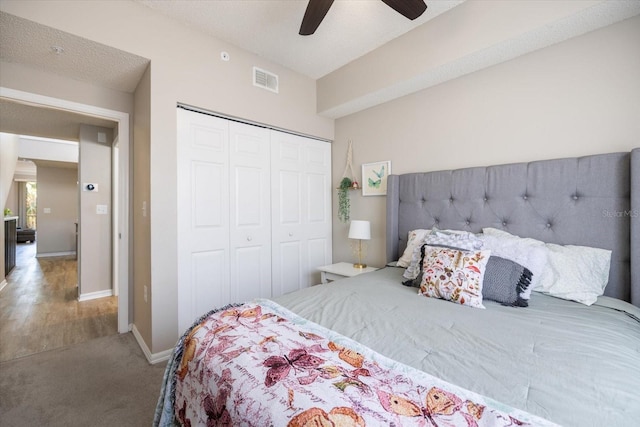 carpeted bedroom with ceiling fan and a closet