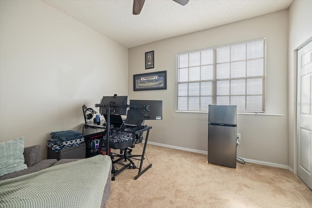 carpeted office with ceiling fan and a textured ceiling