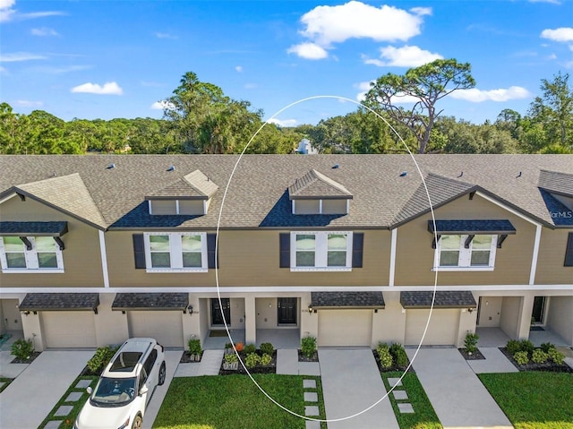 view of property with a shingled roof, driveway, and an attached garage