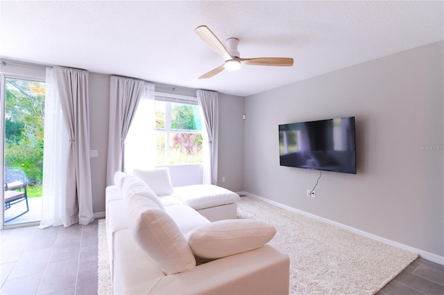 living room featuring tile patterned flooring, a textured ceiling, and ceiling fan