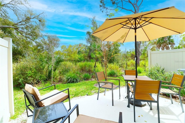 exterior space featuring outdoor dining area and fence