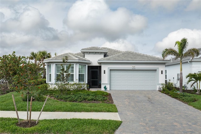 view of front of property featuring a garage, decorative driveway, and stucco siding