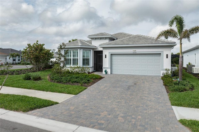 view of front of house with an attached garage, decorative driveway, and stucco siding