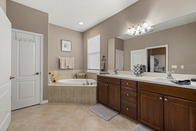 bathroom with tile patterned flooring, vanity, and a relaxing tiled tub