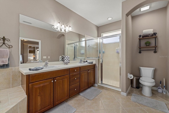 bathroom featuring tile patterned flooring, vanity, and a shower with door