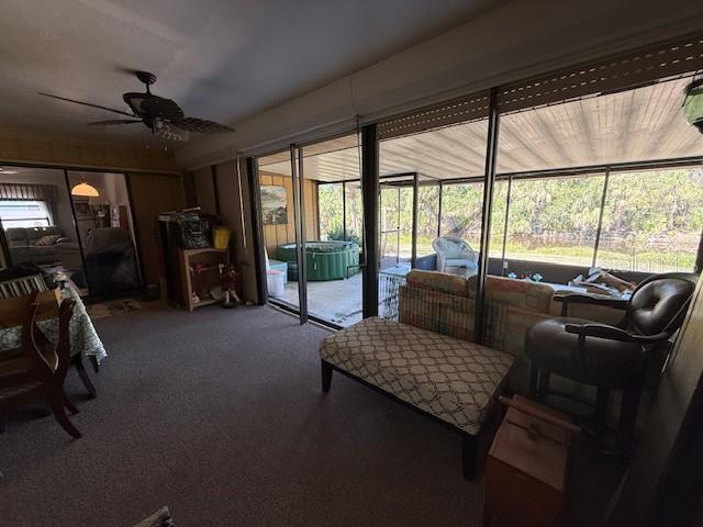 interior space featuring ceiling fan, carpet floors, and a healthy amount of sunlight