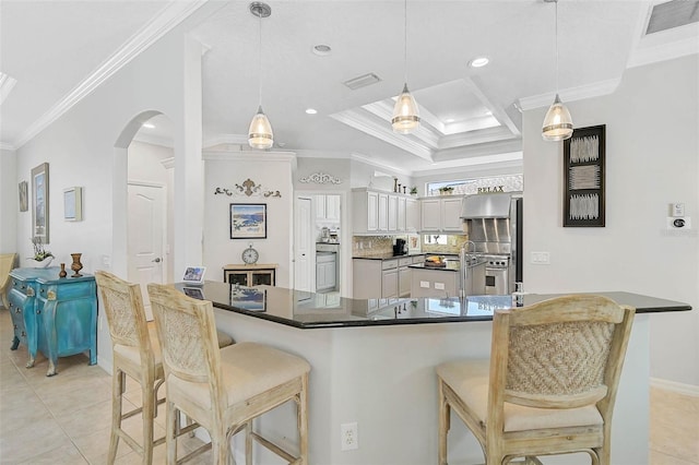 kitchen with white cabinetry, a kitchen bar, ornamental molding, light tile patterned flooring, and decorative light fixtures