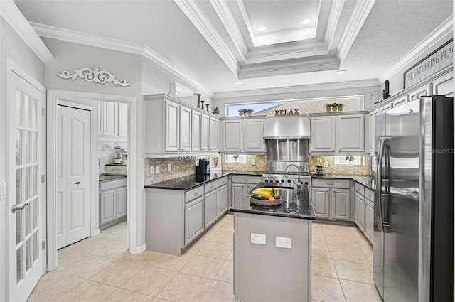 kitchen with gray cabinets, dark stone countertops, stainless steel appliances, an island with sink, and light tile patterned flooring