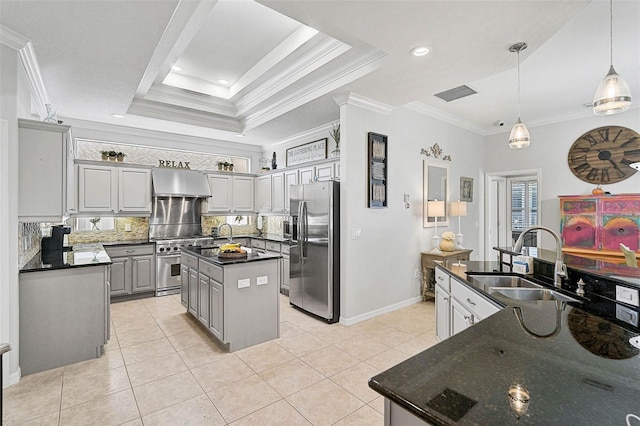 kitchen with sink, gray cabinetry, a center island, appliances with stainless steel finishes, and a raised ceiling