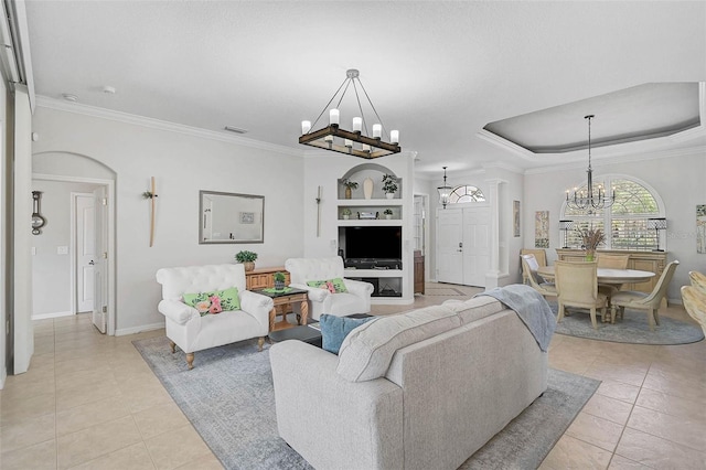 living room featuring crown molding, light tile patterned floors, a chandelier, and a tray ceiling