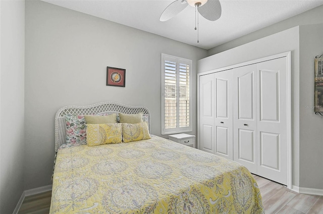 bedroom with ceiling fan, a closet, and light hardwood / wood-style flooring