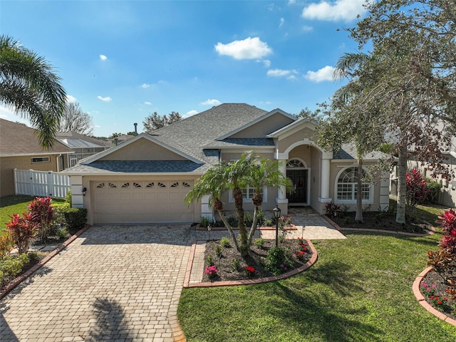 ranch-style home featuring a garage and a front lawn