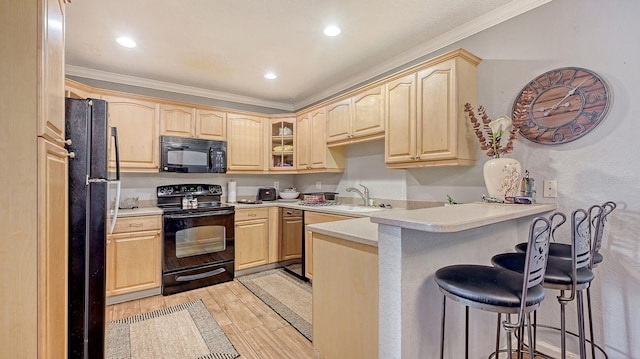 kitchen with sink, light brown cabinets, a kitchen breakfast bar, kitchen peninsula, and black appliances