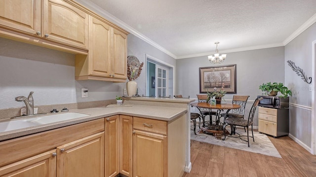 kitchen with sink, an inviting chandelier, hanging light fixtures, light hardwood / wood-style flooring, and light brown cabinets