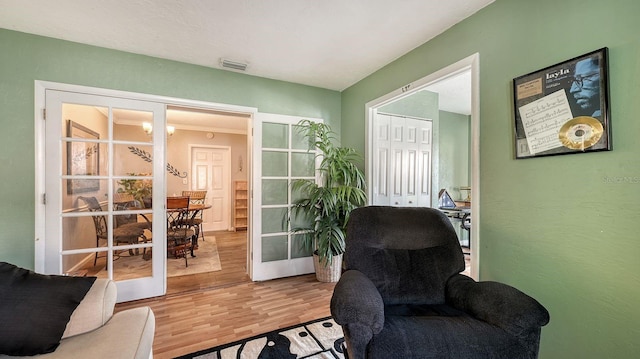 sitting room with hardwood / wood-style flooring and french doors