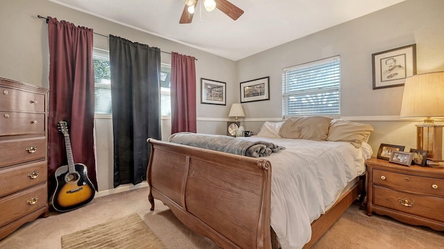 bedroom featuring multiple windows, light colored carpet, and ceiling fan