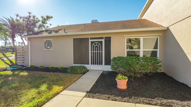 entrance to property featuring a lawn