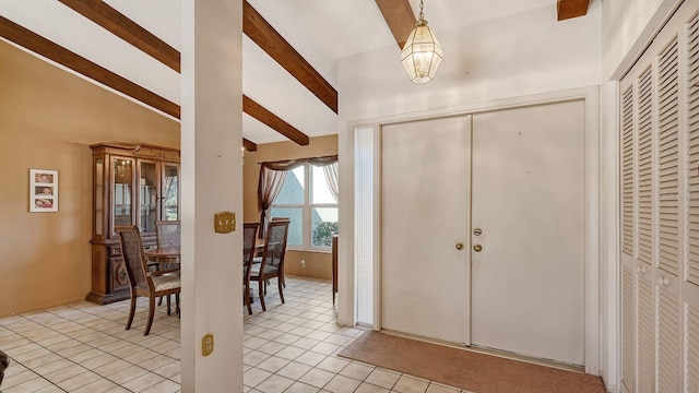 tiled entryway with vaulted ceiling with beams