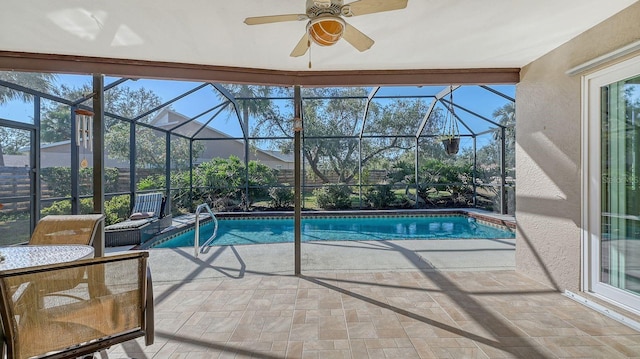 view of swimming pool featuring a patio, ceiling fan, and glass enclosure