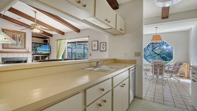 kitchen with white cabinetry, dishwasher, sink, hanging light fixtures, and a textured ceiling