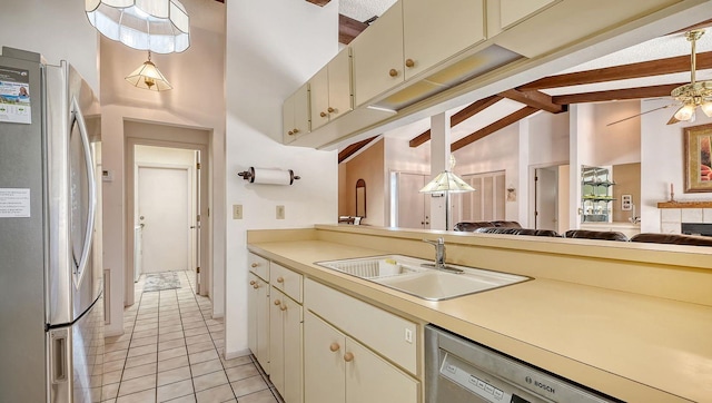 kitchen featuring stainless steel appliances, sink, pendant lighting, and vaulted ceiling with beams