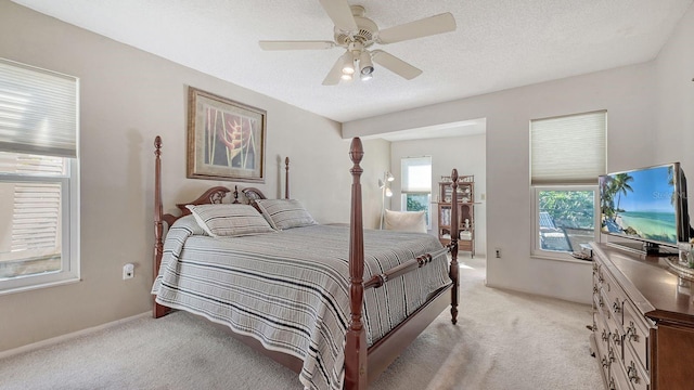 bedroom featuring ceiling fan, light carpet, and a textured ceiling