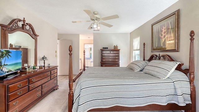 carpeted bedroom featuring ceiling fan and a textured ceiling