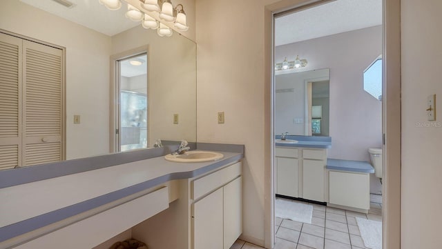 bathroom featuring tile patterned floors, toilet, a shower with door, and vanity