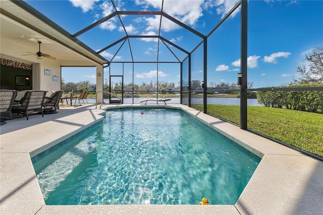 view of pool with a water view, glass enclosure, a yard, ceiling fan, and a patio